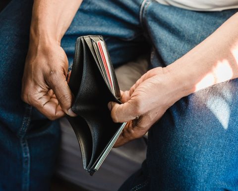 man looking at an empty wallet