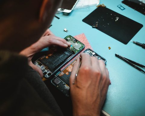 person repairing smartphones under a lighted table