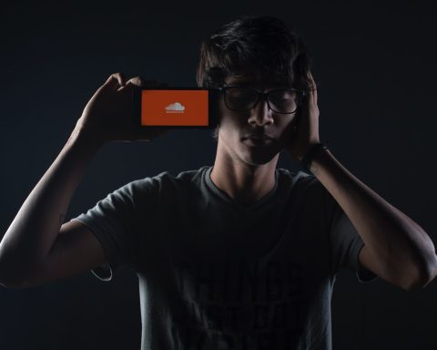 man listening to Soundcloud music on smartphone