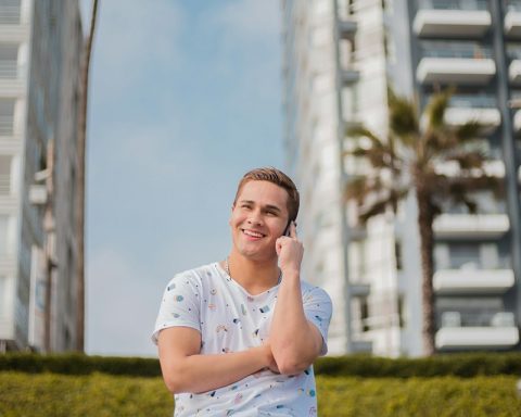 smiling man sitting on metal screen