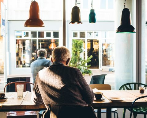 man in chair with table beside coffee