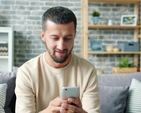 Man sitting on couch using a smartphone