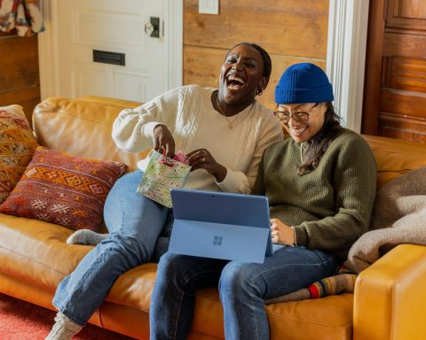 a person sitting on a couch with a laptop