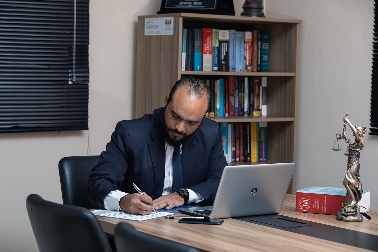 Kantoormedewerker aan bureau met documenten en laptop in zakelijke omgeving