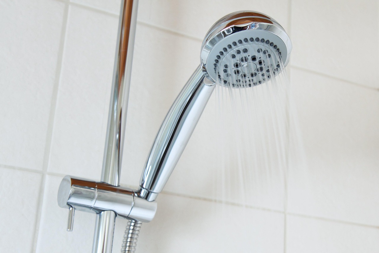 Een spaardouchekop met waterstraal in een badkamer