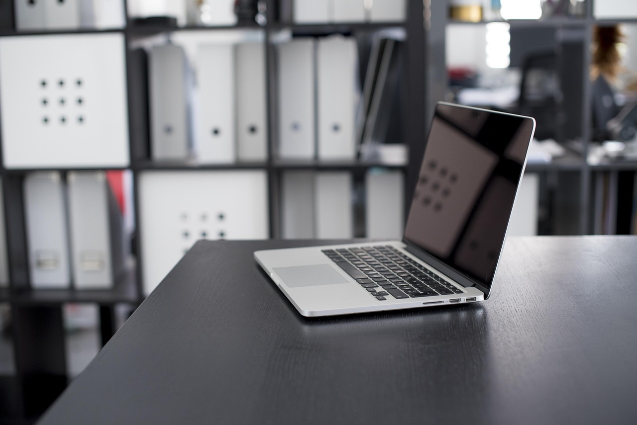Een MacBook en een goedkope Windows-laptop naast elkaar op een bureau
