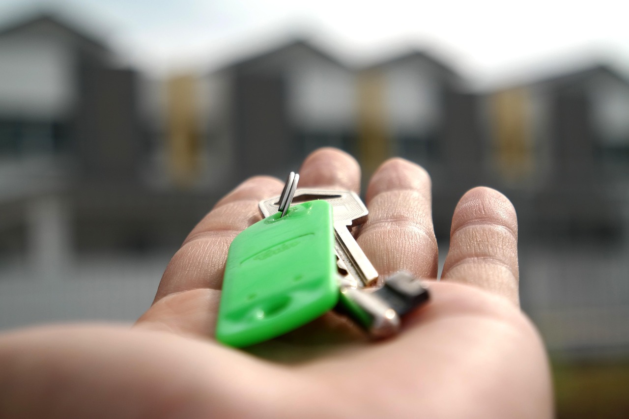 Huissleutels in de hand van een nieuwe huiseigenaar bij de voordeur
