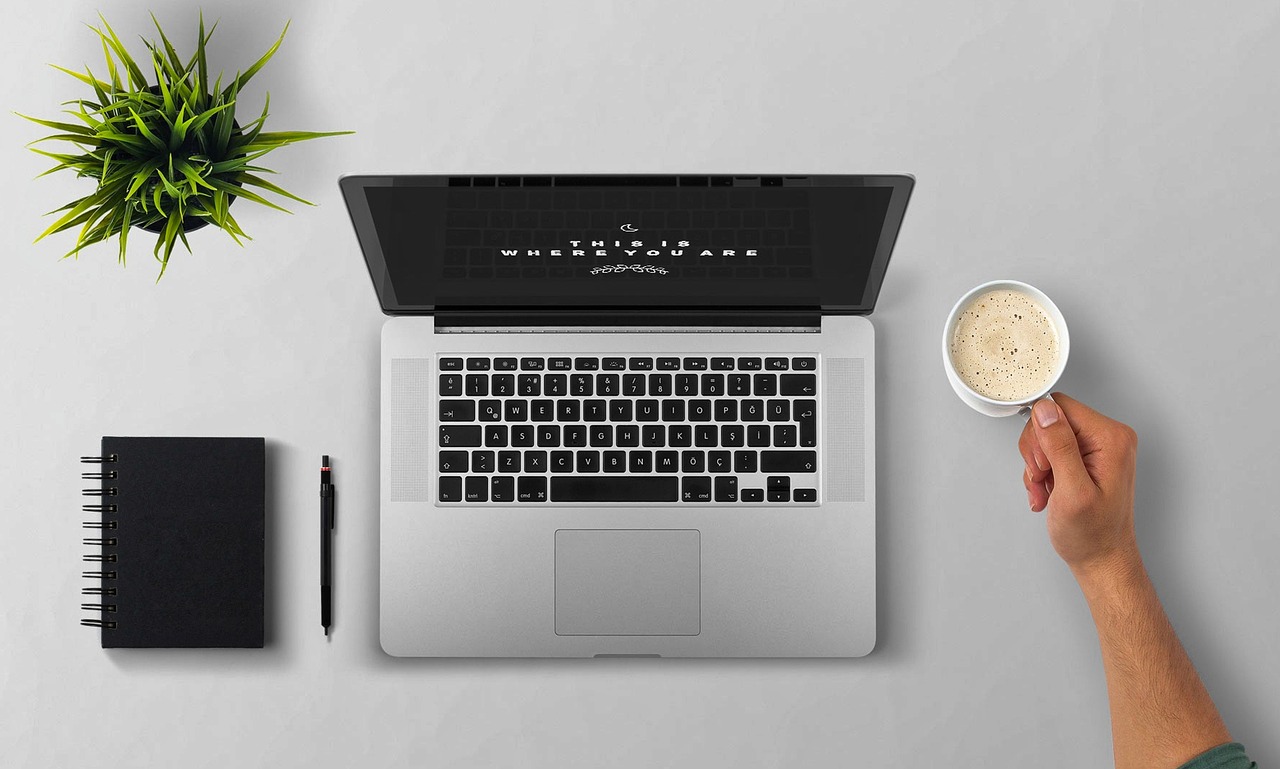 Persoon die thuis aan een bureau werkt naast papieren met berekeningen
